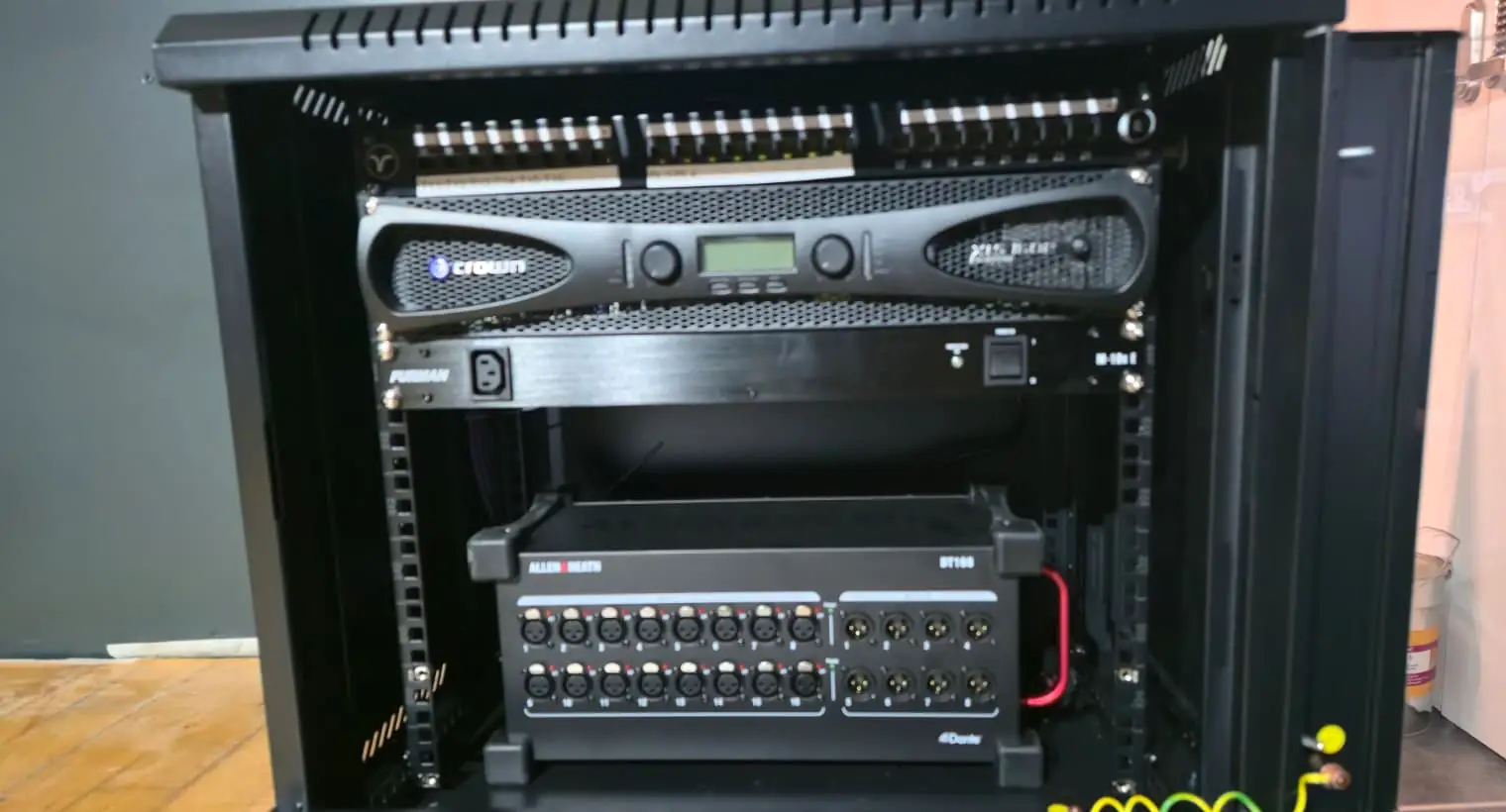 Dante-enabled stage box, amplifiers and network equipment in an AV rack at The Ruze